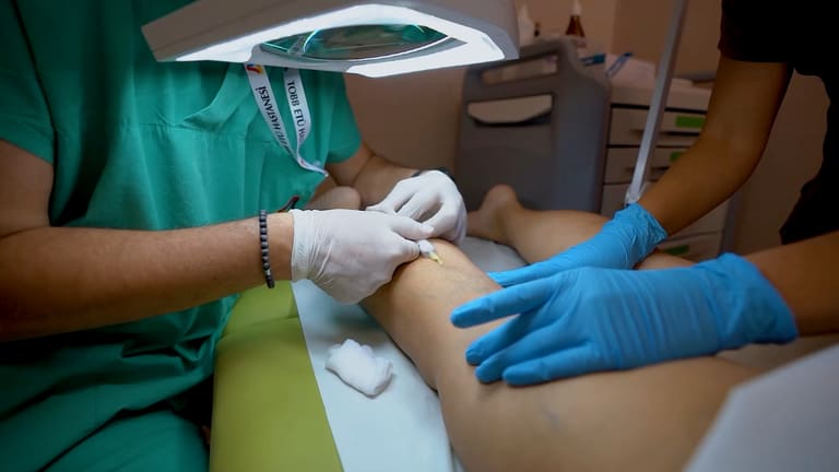 A procedure on the leg performed with gloved hands at the clinic